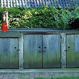 Oude houten kast bij Vakantiehuis in Oeffelt, Noordoost Brabant, omgeven door groene natuur.