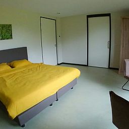 Comfortabele slaapkamer in Vakantiehuis in Erp, Noord Brabant, met geel beddengoed.