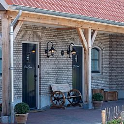 Charmante entree van Vakantiehuis in Sint-Oedenrode, Noordoost Brabant, met landelijke veranda en authentieke sfeer.