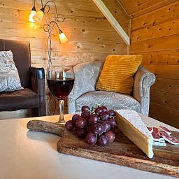 Knusse zithoek in Huisje in Vortum Mullem, vakantieverblijf in Vortum-Mullem, Noord-Brabant, met wijn en kaasplank.