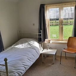 Sfeervolle slaapkamer in Vakantiehuisje in Keent, Noordoost Brabant, met uitzicht op groene velden.