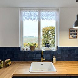 Moderne keuken in Vakantiehuisje in Ossendrecht met uitzicht op het platteland.