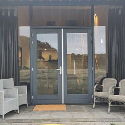 Eingang zum Cottage in Rucphen, einem modernen Ferienhaus in Westbrabant, Nordbrabant, mit Blick auf die Natur vom Flur aus.