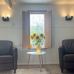 Stilvolle Sitzecke im Cottage in Hoogerheide, Ferienhaus in Hoogerheide, mit Ledersesseln und einem Beistelltisch.