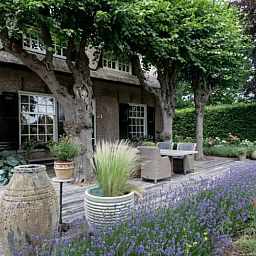 Veranda met levendige bloemen bij vakantiehuis in Roosendaal, West Brabant.