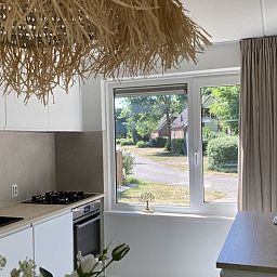 Moderne keuken in Villa Wellness Retreat, een vakantiehuis in Halderberge, West Brabant, met uitzicht op groene omgeving.