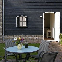 Terrasse von Haus in Drimmelen, Ferienhaus in Nordbrabant mit Sitzecke und gruener Umgebung.