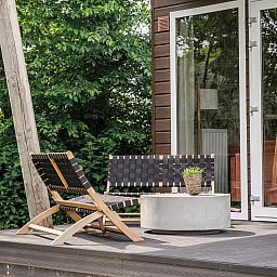 Cozy terrace of Beach House sleeps 6, vacation home in Julianadorp, North Sea coast, North Holland, with modern seating area and green surroundings.