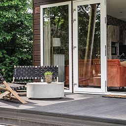 Veranda of Beach House sleeps 6 in Julianadorp, North Holland, with modern seating areas and views of green nature on the North Sea coast.