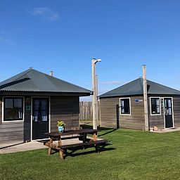 Ferienhaus in Julianadorp, Nordseekueste, Nordholland, mit Holzterrasse und gruener Umgebung fuer einen erholsamen Aufenthalt.