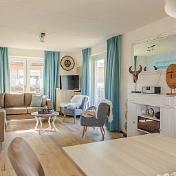 Stijlvolle woonkamer in Villa Luxe 6, een vakantiehuis in Julianadorp aan de Noordzeekust, Noord-Holland, met moderne inrichting en veel licht.