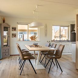 Moderne eetkamer in Villa Luxe 6, een vakantiehuis in Julianadorp aan de Noordzeekust, Noord-Holland, met veel natuurlijk licht.