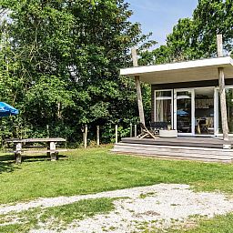 Strandhuisje 5 personen in Julianadorp, Noordzeekust, Noord-Holland met veranda en groene omgeving voor een ontspannen vakantie.