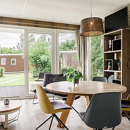 Gezellige binnenruimte van Strandhuisje 5 personen in Julianadorp, Noordzeekust, met uitzicht op tuin en terras.