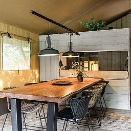 Binnenruimte van Strandtent 8 personen in Julianadorp, Noordzeekust, Noord-Holland, met gezellige eetruimte en houten interieur.