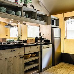 Moderne Kueche im Strandtent 6 Personen, einer Glamping Lodge in Julianadorp an der Nordseekueste, Nordholland, mit hoelzernem Interieur und geraeumigen Einrichtungen.