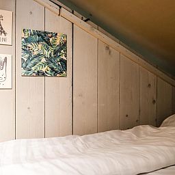 Gemuetliche Einrichtung des Strandzeltes 6 Personen in Julianadorp, Nordseekueste. Inneneinrichtung aus Holz mit dekorativer Kunst an der Wand.