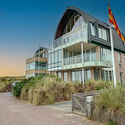 Ferienhaus De Garnaal in Egmond aan Zee, Nordseekueste, Nordholland, mit moderner Architektur und Blick auf die Duenen.