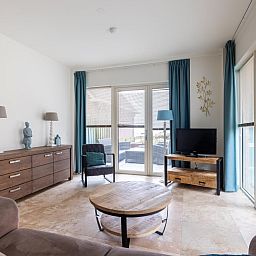 Cozy living room of vacation home De Platvis in Egmond aan Zee, North Sea coast, North Holland, with comfortable furnishings and a view of the terrace.