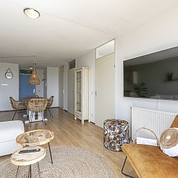 Gemuetliches Wohnzimmer im Ferienhaus Duinerei B202 Groote Keeten, Callantsoog, mit grossem Flachbildfernseher.