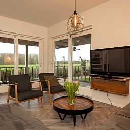 Moderne woonkamer van Vakantiehuisje in Callantsoog met uitzicht op de Noordzeekust, Noord-Holland.