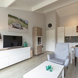 Stilvoller Innenraum des Beach Apartment 35 Callantsoog mit Essbereich und Kueche.