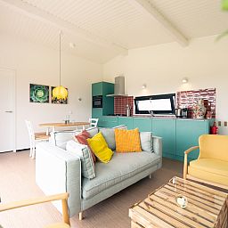 Stilvolles Wohnzimmer von Royal Dune 4, Callantsoog, mit moderner Kueche und farbenfrohen Moebeln.