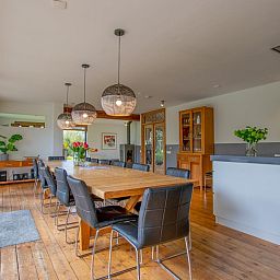 Gezellige eetkamer in Landhuis Duinzicht, een vakantiehuis in Callantsoog aan de Noordzeekust, Noord-Holland, met houten vloeren en moderne inrichting.
