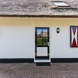 Charmanter Eingang zu einem freistehenden Haus in Callantsoog, an der Nordseekste in Nordholland gelegen, mit Reetdach und lndlicher Atmosphre.