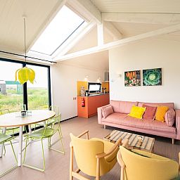 Bright interior space of Callants Comfort 4 in Callantsoog, with cozy sitting area and dining area.