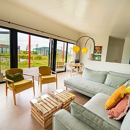 Lichte binnenruimte van Farmland Family 6, een vakantiehuis in Callantsoog aan de Noordzeekust, met uitzicht op de tuin.
