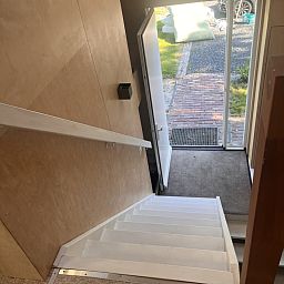 Ingang van vakantiehuis NH581 in Groet, Noordzeekust, Noord-Holland, met uitzicht op de tuin en een uitnodigende trap naar binnen.