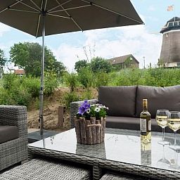 Gezellig terras bij Huisje in Egmond aan den Hoef met uitzicht op een molen, Noordzeekust, Noord-Holland.