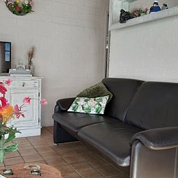 Gezellige woonkamer van Rekere 111 vakantiehuis in Schoorldam, Noordzeekust, Noord-Holland met comfortabele bank.