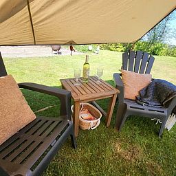 Ontspan op het terras van Huisje in Schagerbrug, Schagerbrug, met comfortabele stoelen en uitzicht op de groene omgeving.