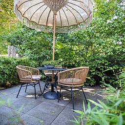 Geniet van het terras bij De Egelhut, een vakantiehuis in Bergen aan de Noordzeekust, omringd door weelderige natuur en rust.