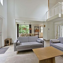 Ruime woonkamer met moderne inrichting in vakantiewoning Julianadorp aan Zee.