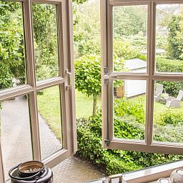 Uitzicht op de groene tuin vanuit Casa Allegria, Bergen, vakantiehuis aan de Noordzeekust in Noord-Holland.