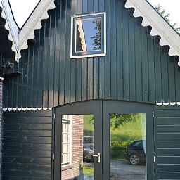 Charmante entree van Vakantiehuis in Andijk, met houten gevel in Noord-Holland, gelegen aan de serene IJsselmeerkust.