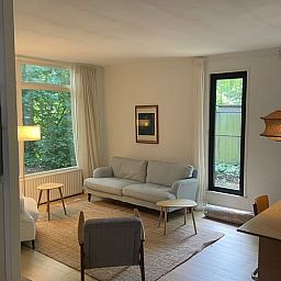 Gemuetliches Wohnzimmer des Ferienhauses in Andijk, Nordholland, mit moderner Einrichtung und viel natuerlichem Licht.