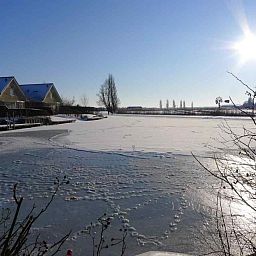 Rustikaler Garten- und Wasserblick vom Ferienhaus NH251 in Medemblik, Nordholland.