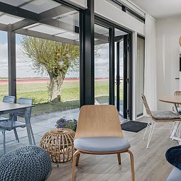 Stilvolle Sitzecke in Lodge 4C, einem Ferienhaus in Wijdenes an der IJsselmeerkueste, Nordholland, mit viel natuerlichem Licht.