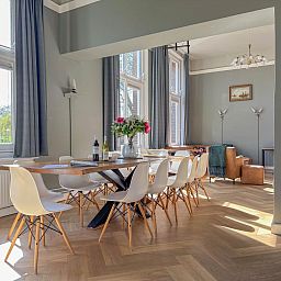 Gezellige eetkamer in vakantiehuis Groot Weeshuis, Enkhuizen, met ruime tafel en veel natuurlijk licht, gelegen aan de IJsselmeerkust, Noord-Holland.