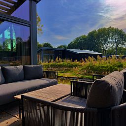 Enjoy the serene veranda of the detached house in Enkhuizen, a vacation home on the IJsselmeer coast in North Holland.