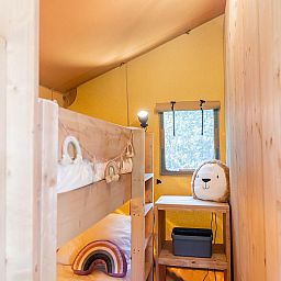 Cozy children's room in De Bos Tent, a glamping lodge in Huizen, North Holland, with bunk beds and playful decorations.