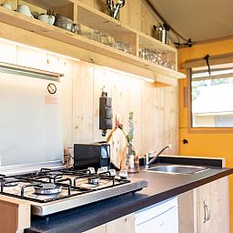 Cozy kitchen in De Bos Tent, an attractive safari tent in Huizen, IJsselmeer coast, North Holland, with modern amenities and natural light.