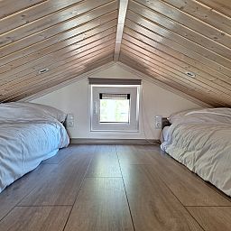 Gezellige zolderkamer met houten dak in Vrijstaande woning in Bovenkarspel, vakantiehuis aan de IJsselmeerkust, Noord-Holland.