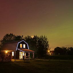 Entdecken Sie die ruhige Nachtatmosphaere im Ferienhaus in Schellinkhout, Nordholland, mit einem wunderschoen beleuchteten Himmel ueber dem Ferienhaus.