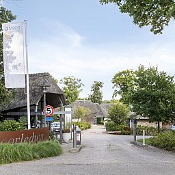Ingang van Vrijstaande woning in Schoorl, een vakantiehuis in Noord-Holland, omgeven door groene natuur en rustieke charme.