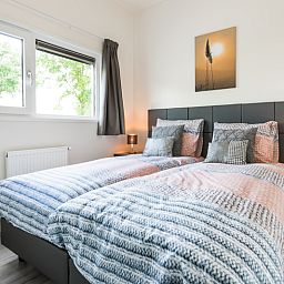 Gemuetliches Schlafzimmer im Modul 5-Personen-Ferienhaus, Berkhout, Nordholland, mit bequemen Betten und beruhigendem Blick auf die Natur.